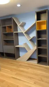 A bookshelf with many shelves and a wooden floor