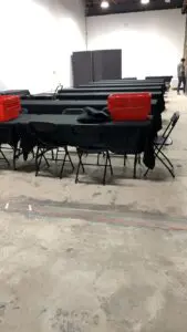 A group of tables and chairs with black table cloths.