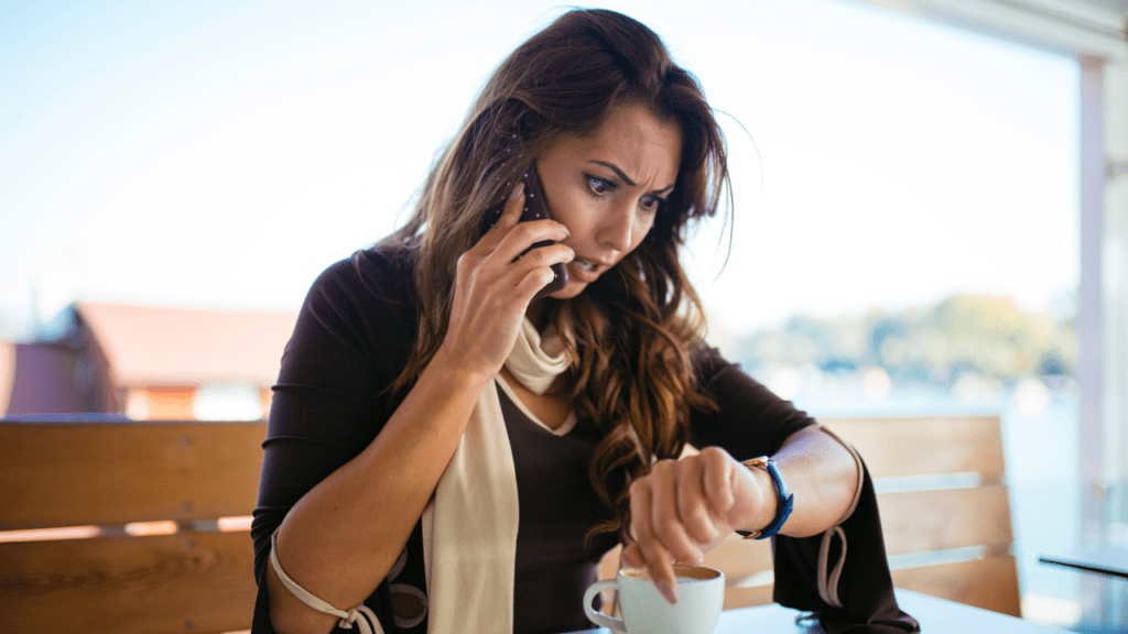 A woman on the phone looking at her watch.