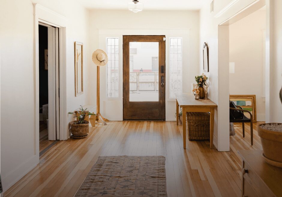 A hallway with wooden floors and white walls.