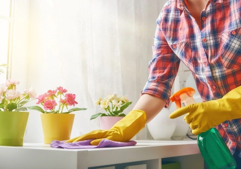 A person in yellow gloves cleaning the counter.